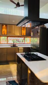 a kitchen with a stove and a refrigerator at South Elegance in Tellicherry