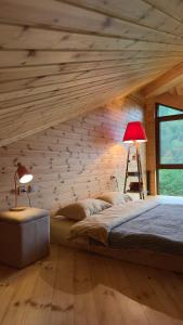 a bedroom with a large bed with a wooden wall at IparAlto in Mestia