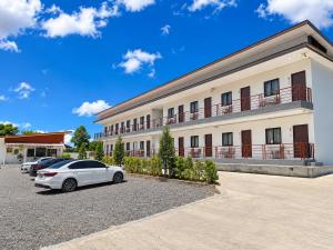 a white car parked in front of a building at Tonjun residence kanjana in Ban Hua Phrong