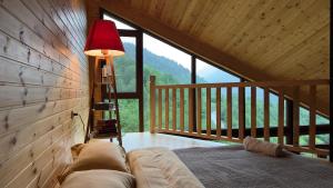 a bed in a room with a large window at IparAlto in Mestia +17 photos