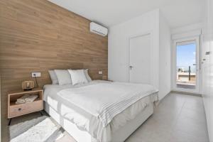 a bedroom with a large bed with a wooden wall at Modern new Pool Villa in San Pedro del Pinatar