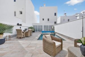a patio with wicker furniture and a swimming pool at Modern new Pool Villa in San Pedro del Pinatar