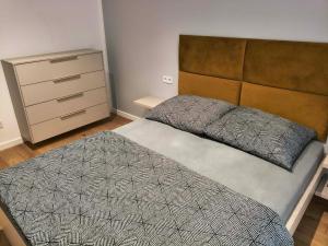 a bedroom with a large bed and a dresser at Apartament Matki Polki I in Łódź