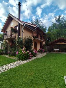 a house with a garden in front of it at Casa Iulia & Matei in Cârțișoara