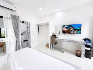 a white bedroom with a bed and a desk at ต้นจันทร์เรสซิเดนซ์ in Chaweng