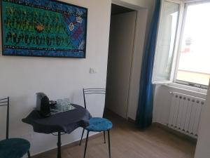 a room with a table and two chairs and a window at Casa Mosaico in Volterra