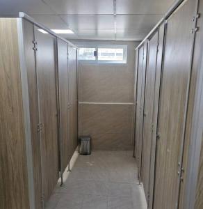 a row of stalls in a bathroom with a walk in shower at Hotel Backpack BTS ปุณณวิถี in Bangkok