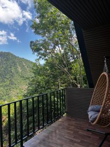 a porch with chairs and a view of the mountains at kesis chalet in Borjomi