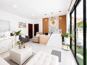 a living room with white furniture and windows at Tonjun residence samui in Chaweng