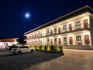 a white car parked in front of a building at night at Tonjun residence samui in Chaweng