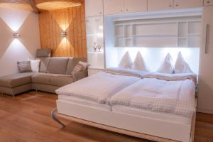 a bedroom with a white bed and a couch at Chalet Heimetli in Grächen