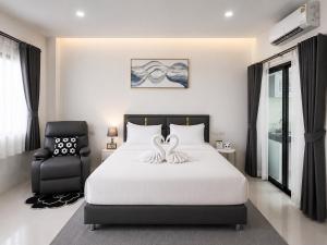 a bedroom with a white bed and a chair at Tonjun residence samui in Chaweng