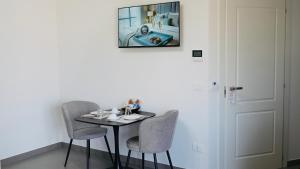 a table with two chairs and a picture on the wall at Mini B&B - Alessandro Volta in Rende +19 photos