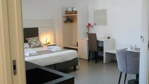 a hotel room with a bed and a desk and a kitchen at Mini B&B - Alessandro Volta in Rende