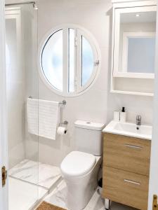 a bathroom with a toilet and a sink and a mirror at Tamaragua Apartment, Golf del Sur in San Miguel de Abona