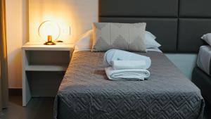 a bed with a suitcase and towels on it at Mini B&B - Alessandro Volta in Rende