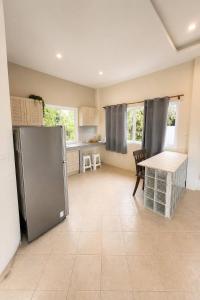 a kitchen with a refrigerator and a table in it at Baan Sawang hidden in tropical calm in Ban Tai