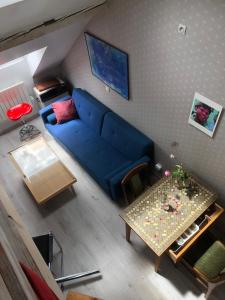 a living room with a blue couch and a table at maison d'artiste chez Bé in Brunstatt