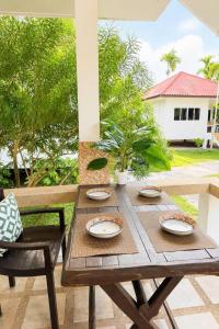 a wooden table and chairs on a patio at Baan Sawang hidden in tropical calm in Ban Tai