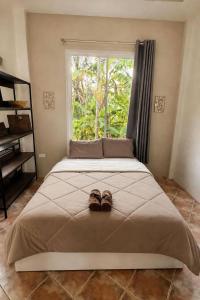 a pair of shoes sitting on a bed with a window at Baan Sawang hidden in tropical calm in Ban Tai +40 photos