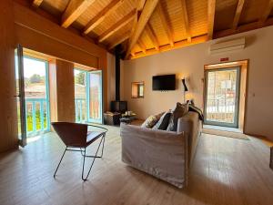 a living room with a couch and a chair at Casa Tritão - Gerês in Campo do Gerês