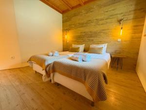a bedroom with a large bed with towels on it at Casa Tritão - Gerês in Campo do Gerês