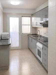 a white kitchen with a sink and a counter at Tamaragua Apartment, Golf del Sur in San Miguel de Abona