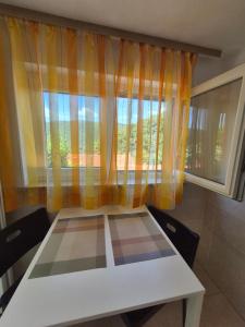 a table and chairs in a room with a window at Studio for short stay in Rabac