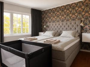 a bedroom with a large bed with a tufted headboard at Villa Bergåsa in Karlskrona