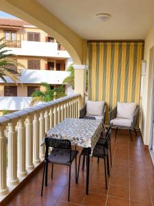 a balcony with a table and chairs on it at Tamaragua Apartment, Golf del Sur in San Miguel de Abona +10 photos
