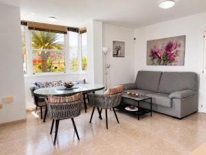 a living room with a couch and a table and chairs at Tamaragua Apartment, Golf del Sur in San Miguel de Abona