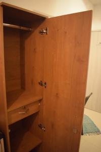 a wooden cupboard with a wooden door in a room at Zen LuxStudio in Pune