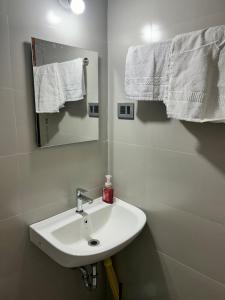a bathroom with a sink and a mirror and towels at Zen LuxStudio in Pune +1 photo