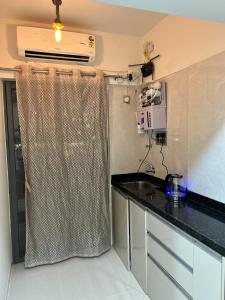 a kitchen with a black counter top in a room at Zen LuxStudio in Pune