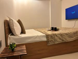 a bedroom with a bed with a table and a tv at Zen LuxStudio in Pune