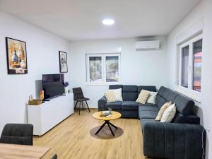 a living room with a blue couch and a tv at Villa Dub in Stolac
