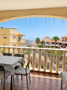a balcony with a table and chairs and a view at Tamaragua Apartment, Golf del Sur in San Miguel de Abona