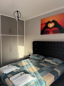 a bedroom with a bed with a heart picture on the wall at Apostolis Apartment in Vonitsa