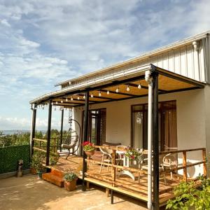 a pavilion with a table and chairs on a patio at Tsikhisdziri Panorama Cottage in Kobuleti