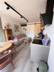a kitchen and living room with a table and a couch at Bed & Breakfast Betuws Genieten in Tiel