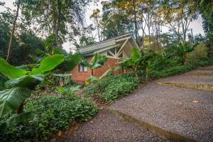 a brick house with a roof in a garden at Raices Amambai Lodges in Puerto Iguazú
