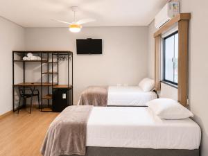 a hotel room with two beds and a television at Hotel Mirante in Careaçu
