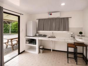 a white kitchen with a sink and a refrigerator at Anluka House mono araña in Puerto Jiménez