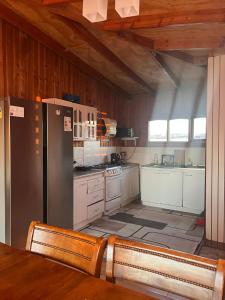 a kitchen with a refrigerator and a table and chairs at Hospedajes CyC in Llanquihue