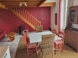 a dining room with a white table and chairs at Le Duplex Bordeaux in Saint-Jean-dʼAngély