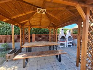 a wooden pavilion with benches on a patio at Appartamenti L'Arcipelago in Marina di Campo