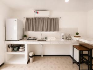 a kitchen with a counter with a sink and a refrigerator at Anluka House mono araña in Puerto Jiménez