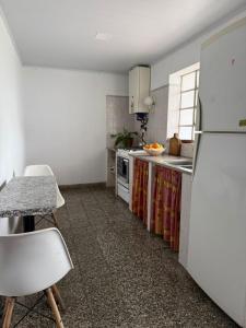 a kitchen with a refrigerator and a table and chairs at Alvarado in San Pedro