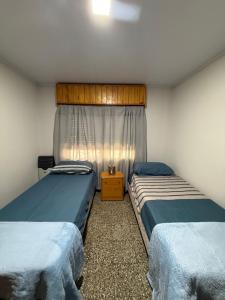 a bedroom with two beds and a window at Alvarado in San Pedro