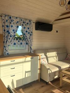 a small room with a couch and a window at Domek Chabrowy Gowidlino in Gowidlino